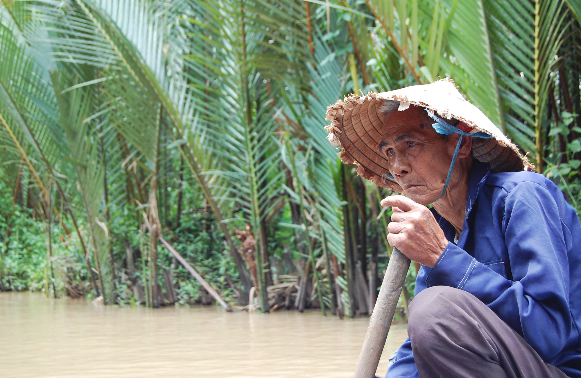 Vietnamese man rowing on the Mekong river in Vietnam
