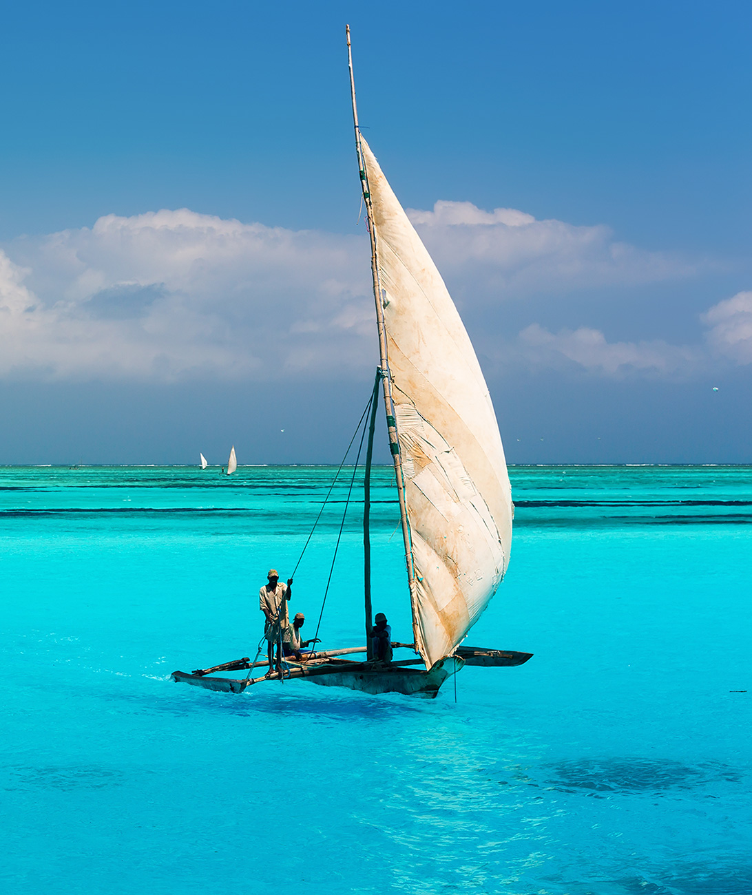 paikallisia purjehtijoita purjeveneessä turkoosinsinisessä merivedessä