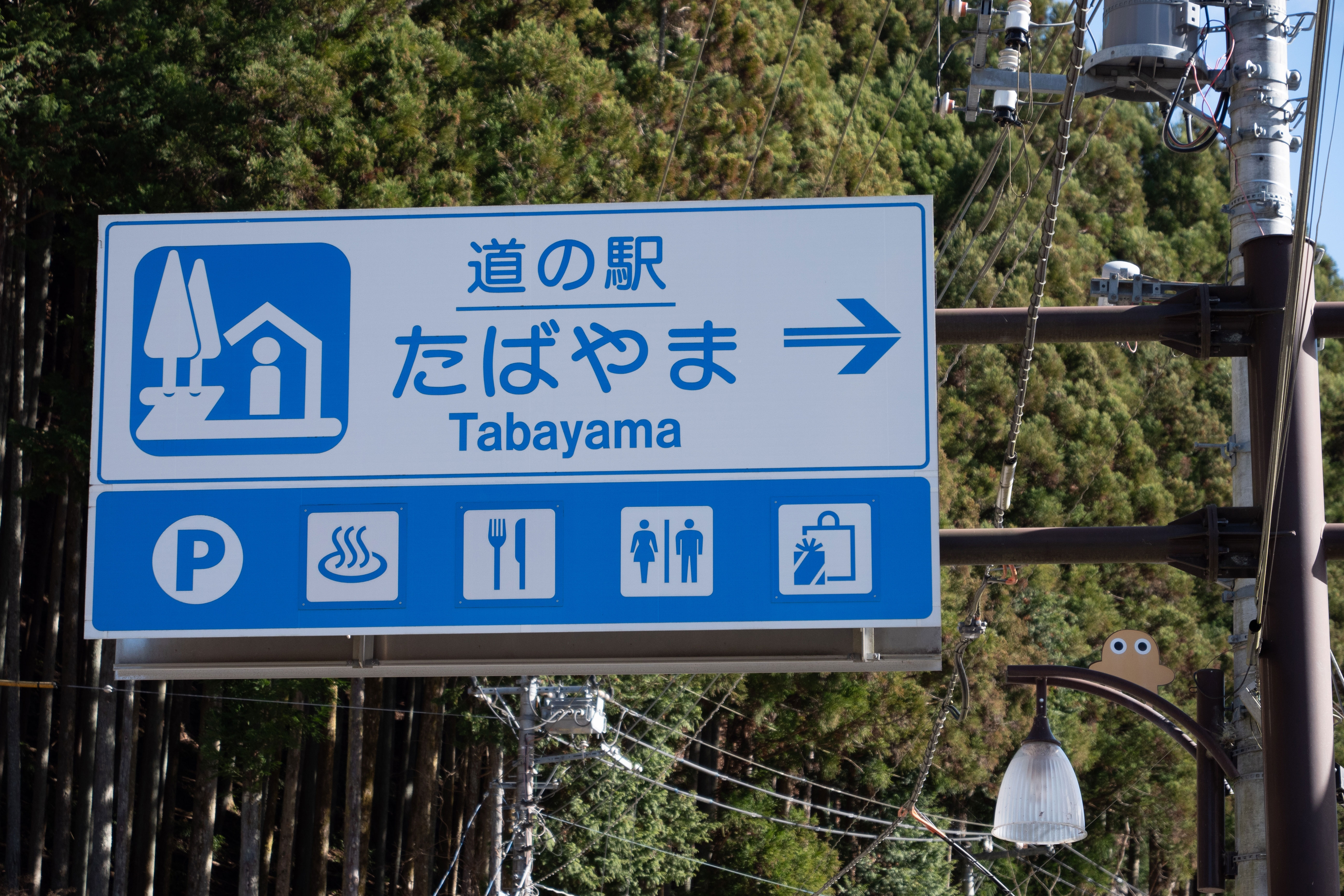 Blue and white road sign in Japan indicating the road side station of Tabayama